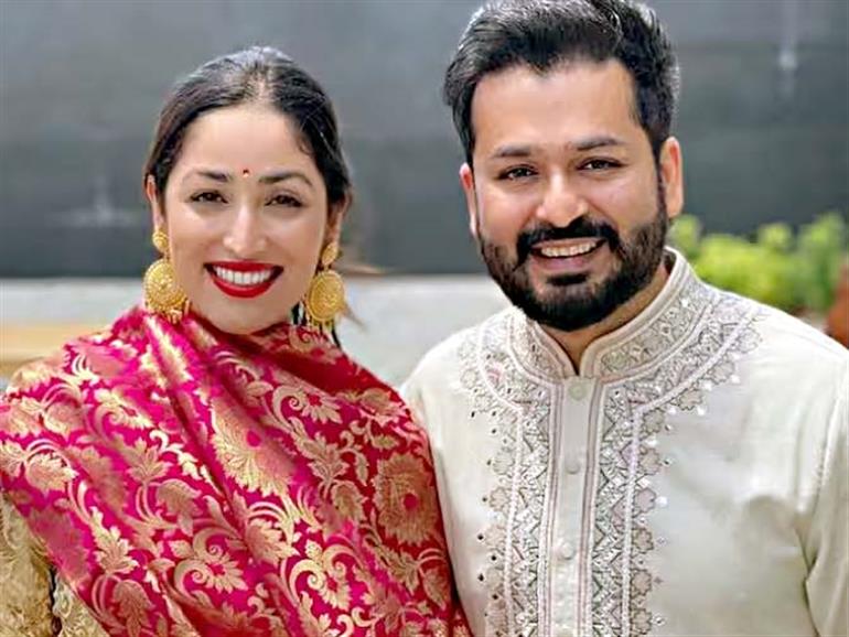 photo of yami gautam's wedding with aditya dhar wearing wedding attire against the backdrop of Himachal pRadesh's mountains